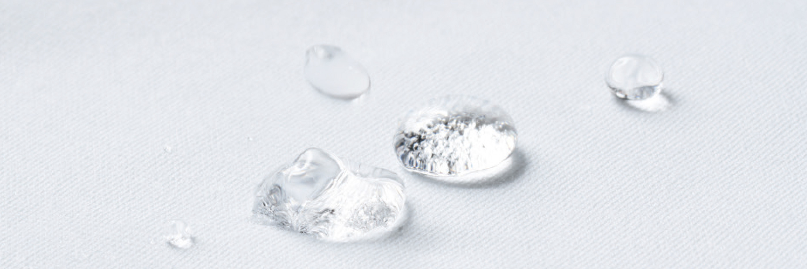 Water droplets collect on white fabric with hydrophobic properties | mey®